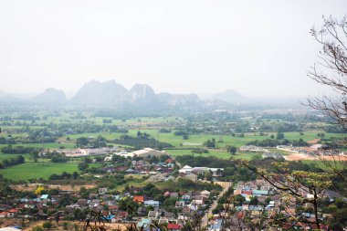 Ratchaburi şehri ve kireçtaşı dağlarının hava manzarası çeltik tarlasıyla Tham Khao Ngu ve Tayland 'ın Ratchaburi kentindeki Khao Kaen Chan tepesindeki ev köyü.