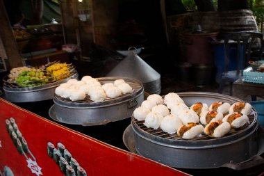 Gezginler için Luang Phor Thuad caddesi pazarında geleneksel Çin mantısı, hamur köftesi ve işlenmiş Çin çöreği. Ayutthaya Tayland 'a gidip içki içiyorlar.