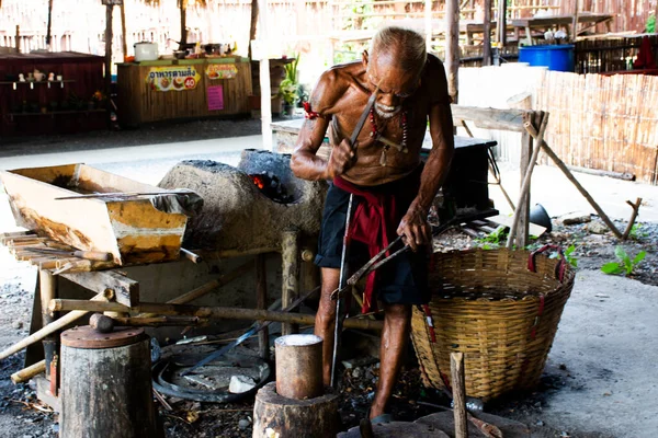 Tajski Starzec Kowal Lub Metalowiec Produkujący Starożytną Żelazną Zbroję Metalową — Zdjęcie stockowe
