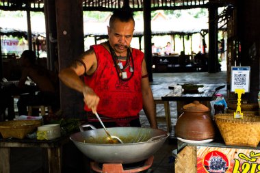 Hawker, 28 Mayıs 2023 'te Sing Buri, Tayland' da bulunan Bang Rachan köyünde geleneksel Thai ürünlerini seyyar gezgin pazarında satıyor.