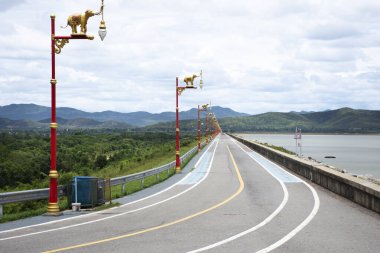 Thai bölgesi Dan Chang bölgesindeki Krasiao toprak barajının tepesindeki manzara dağı ve sokak yolunu gezginler ziyaret edip Suphan Buri Tayland 'daki Suphanburi şehrinde dinleniyorlar.