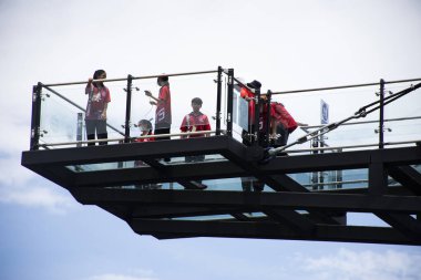 Tayland halkı için Khwae Yai ya da Si Sawat nehrinin kıyısına paralel uzanan Skywalk köprüsü 30 Ağustos 2023 tarihinde Kanchanaburi, Tayland 'daki açık cam köprüde yabancı gezginler ziyaret ve yürüyüş yapar.