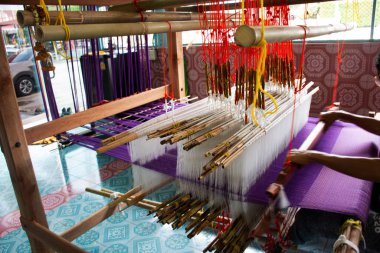 Tayland zanaat teknisyeni profesyonel antika yerel ahşap makine dokuma tezgahı el dokuması pamuk kumaşı gezginlerin Nonthaburi, Tayland 'daki stüdyo el yapımı el sanatları atölyesini ziyaret etmesi için