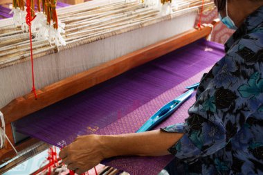 Tayland zanaat teknisyeni profesyonel antika yerel ahşap makine dokuma tezgahı el dokuması pamuk kumaşı gezginlerin Nonthaburi, Tayland 'daki stüdyo el yapımı el sanatları atölyesini ziyaret etmesi için