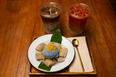 Geleneksel Tayland tatlıları tatlı yemek ve hindistan cevizi sütlü muz ile bezelye dondurması ve kahve çayı müşteriler Bangkok Tayland 'daki restoran kafeteryasında içki içerler.