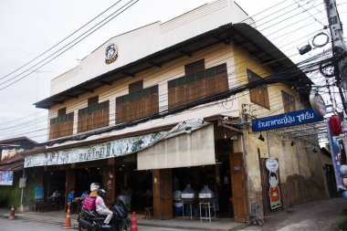 Taylandlı gezginler, Tayland 'ın Ratchaburi şehrinde 16 Eylül 2023' te Rat Buri şehrinde içki içerek yerel restoran kafe dükkanının antika binasını ve antika retro mimarisini kullanırlar.