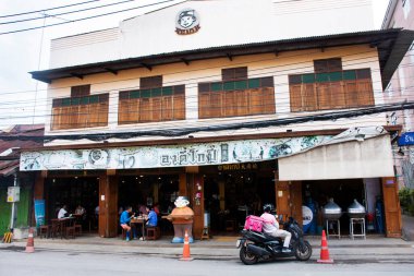 Taylandlı gezginler, Tayland 'ın Ratchaburi şehrinde 16 Eylül 2023' te Rat Buri şehrinde içki içerek yerel restoran kafe dükkanının antika binasını ve antika retro mimarisini kullanırlar.