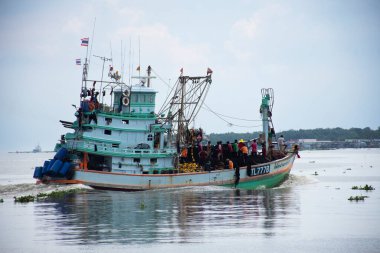 Taylandlı balıkçılar, 24 Eylül 2023 'te Tayland' ın Samut Sakhon kentinde bulunan Chalom Mahachai şehrinde Tha Chin nehrinde balık ve deniz yaşamı yakaladıktan sonra denizde balıkçı teknesi kullanıyorlar.