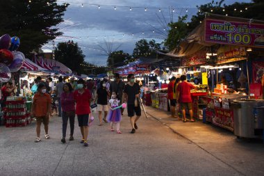 Taylandlılar 1 Ekim 2023 'te Nonthaburi Tayland' da Kathin törenini ve Wat Phai Lueang Tapınağı 'nın yıllık etkinlik festivalini ziyaret eder ve Bang Bua Thong' daki yerel dükkandan içki yer.