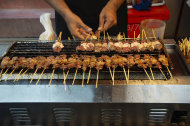 Taylandlı aşçı, Tayland 'ın Nonthaburi kentindeki Tapınak Festivali' nin sokak pazarında içki içen Taylandlı insanlar için baharatlarla marine edilmiş en iyi sığır türünü pişiriyor.