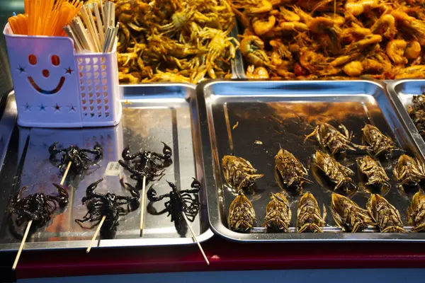 Thai vendor merchant cooked local exotic cuisine from bug and herbal or food fried insect with herb at stall hawker for sale traveler people travel visit in street market bazaar in Nonthaburi Thailand