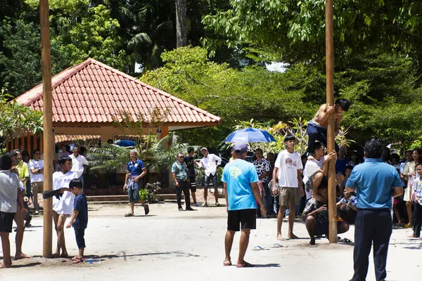Tayland yerlileri, 10. Ay Festivali 'nde sütunları almak ya da 12 Ekim 2023' te Phatthalung, Tayland 'da aç hayaletleri yakalamak için tırmanma ayinine katılıyor.