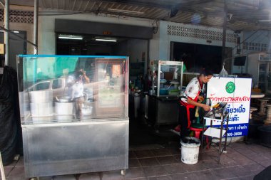 Tayland 'da yerel halk için yemek pişiren Taylandlı aşçı 12 Ekim 2023' te Surat Thani, Tayland 'da bulunan Suratthani eski kasabasındaki yerel pazar pazarında antika binalar ve antika retro restoranlar yiyor.