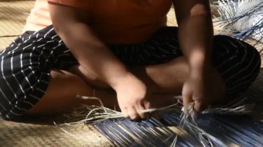 Tayland 'da Phatthalung, Tayland' da Thale Noi 'deki el sanatları atölyesinde özel el yapımı krachut ya da sedge ürünleri satmak için hasır örgü ören profesyonel bir zanaatkar teknisyen.