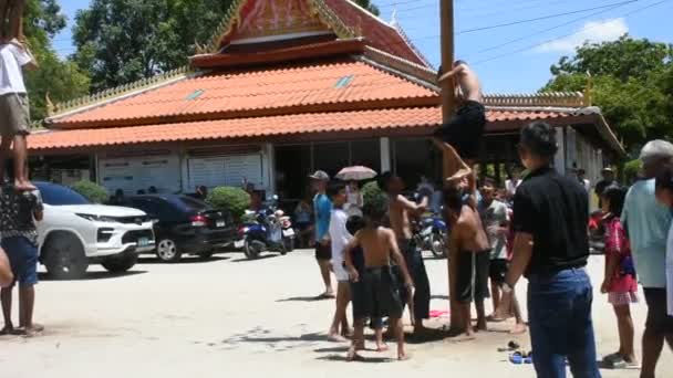 タイの地元の人々は 10月10日の月の祭典でポールでピックオイルポールを取る儀式に参加したり 2023年10月14日 タイのパッタンシュタットでワットクアン マフラオ寺院でサトゥアンシップに参加します — ストック動画