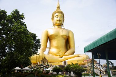 Tayland 'ın Ang Thong kentindeki Angthong şehrindeki Wat Muang tapınağının kutsal ve gizemli tapınağını ziyaret edip kutsayan Taylandlı gezginler için açık alandaki antik altın Buda heykeli.