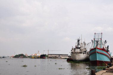 Balıkçı teknesi ve denizde yüzen General kargo gemisi, Samut Sakhon Tayland 'da Tha Chalom ve Mahachai' de Tha Chin nehri ve Mahachai balıkçı köyünde okyanusta balık yaşamı yakalıyor.