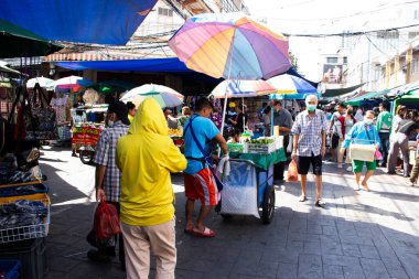 Taylandlı müşteriler ve yabancı gezginler için sabah sampeng yerel pazarı veya phahurat sokak pazarı 19 Kasım 2023 'te Bangkok Tayland' da alışveriş ürünleri mağazasını ziyaret edip seçiyorlar.