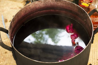 Taylandlı zanaatkar Batik ikat 'te çalışıp kravat bağlarken el yapımı atölyede ve Tayland' ın Pathum Thani kentindeki Bilge Kral Çiftliği festivalinde el işi atölyesinde kaynatılmış Shellac 'ın doğal pembe rengini boyuyor.