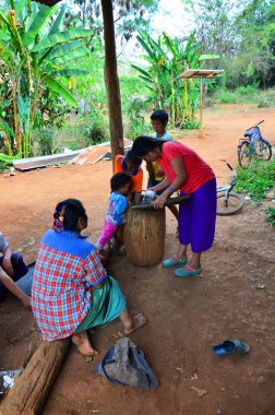 Geleneksel halk bilgeliği kabilesi Karen insanları, 14 Mayıs 2011 'de Suphan Buri, Tayland' da yerel yemek pişirmek için büyük ahşap havan ve büyük ahşap tokmak kullanırlar.