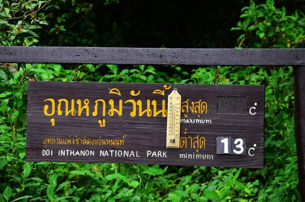 Tayland 'ın başkenti Chiang Mai' de 7 Temmuz 2013 'te Doi Inthanon Ulusal Parkı' nın tepesindeki Doi Luang ya da Ang Ga 'ya seyahat eden insanlar için termometre uyarı levhası yerleştirin.