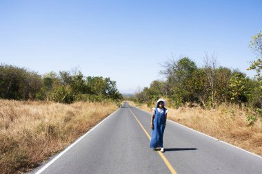 Gezgin Tayland 'ın Lopburi kentindeki Phatthana Nikhom şehrindeki Khao Phraya Doen Thong dağındaki kırsal sokak yolunda fotoğraf çektirmek için seyahat eden Taylandlı kadınlar ziyaret ediyor ve poz veriyorlar.