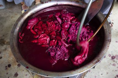 Taylandlı gezginler Baan Phu Chuang 'da Uthai Thani, Tayland' da Ban Rai 'de el işi atölyesinde Batik ikat öğrenme ve kaynamış plastikten doğal pembe boyayı bağlama eğitimi alıyorlar.