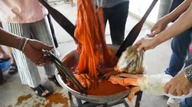 Batik ikat 'te çalışan Taylandlı zanaatkar, Tayland' ın Uthai Thani kentindeki Ban Rai şehrinde Baan Phu Chuang 'da el işi atölyesinde kaynatılmış Bixa orellana fıstığının doğal turuncu rengini boyuyor.