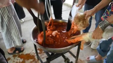 Batik ikat 'te çalışan Taylandlı zanaatkar, Tayland' ın Uthai Thani kentindeki Ban Rai şehrinde Baan Phu Chuang 'da el işi atölyesinde kaynatılmış Bixa orellana fıstığının doğal turuncu rengini boyuyor.