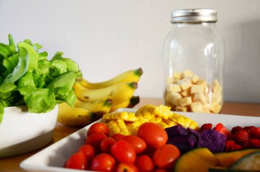 Salata pişirmek için seramik tabağa karıştırılmış sağlıklı sebzeler ve birçok meyve Tayland 'ın Bangkok kentindeki restoran kafeteryasında yemek yiyip içenlere servis ediliyor.