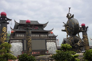 Totem Pole ve Çinli kadın oyuncular gösteri yolcuları için klong ya da büyük davul heykeli çalıyorlar. İnsanlar 11 Mayıs 2024 'te Çin' in Hunan Opera ve Dans Tiyatrosu 'na gidiyorlar.