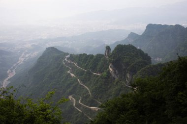 Manzara sıradağları ve yol 99 eğrisi Çinliler için dönüş Tianmen Şah Mağarası Cennet Kapısı Tianmenshan Dağı Ulusal Orman Parkı 'ndaki Hunan, Çin' deki Zhangjiajie 'ye