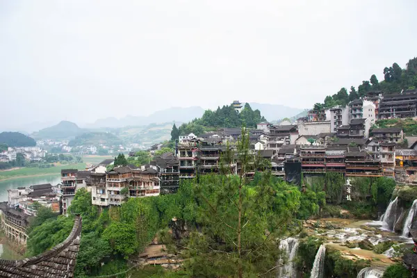 stock image Cityscape historic building antique architecture of Furong Zhen Tujia ancient town with landscape mountain waterfall and youshui river for chinese travelers travel visit on May 9, 2024 in Hunan, China