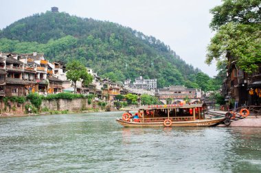Çin hizmet turu için Tuojiang Nehri 'ndeki antika tekne Xiangxi Phoenix Antik Şehir Feng Huang' ının tarihi yapısını ziyaret ediyor 9 Mayıs 2024 'te Hunan, Çin' de