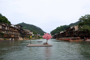 Hizmet turu için Tuojiang Nehri 'ndeki antika ahşap tekne. Çinliler, Xiangxi Phoenix Antik Şehri' nin tarihi yapılarını ya da Hunan Çin 'deki Antik Şehir Feng Huang' ını ziyaret ediyor.