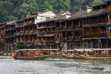 Çin servis turu için Tuojiang Nehri 'ndeki Retro vintage tekne Xiangxi Phoenix Antik Şehir Feng Huang' ın tarihi yapısını 9 Mayıs 2024 'te Çin' in Hunan kentinde ziyaret eder.