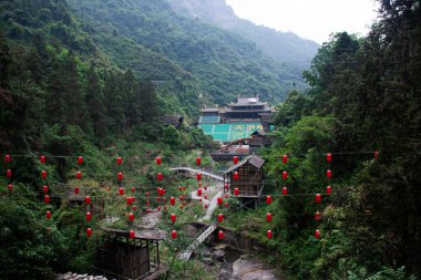 View landscape Tianmen Mountain with antique building architecture of stage theater chinese actor actress acting love story of woodman and fairy fox for show travelers on May 9, 2024 in Hunan, China clipart