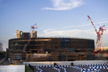 Asyalı işçiler ve Japon işçiler, 4 Temmuz 2024 'te Tokyo, Japonya' da, Odaiba 'daki inşaat sahasında yeni yapı binaları inşa etmek için makineler kullanırlar.