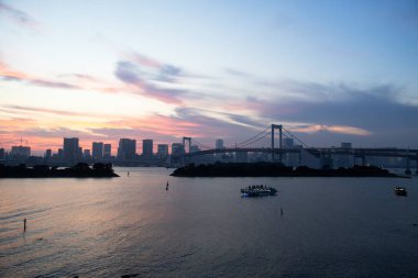 Tokyo Körfezi ve Odaiba rıhtımındaki gezici tekneyle Gökkuşağı Köprüsü 'nün manzarasına bakın. Japon gezginler için seyahat gezisi. Bakış açısı: Tokyo, Japonya' nın Minato şehrinde Daiba manzarası.