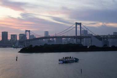 Tokyo Körfezi ve Odaiba rıhtımındaki gezici tekneyle Gökkuşağı Köprüsü 'nün manzarasına bakın. Japon gezginler için seyahat gezisi. Bakış açısı: Tokyo, Japonya' nın Minato şehrinde Daiba manzarası.