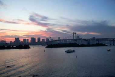 Tokyo Körfezi ve Odaiba rıhtımındaki gezici tekneyle Gökkuşağı Köprüsü 'nün manzarasına bakın. Japon gezginler için seyahat gezisi. Bakış açısı: Tokyo, Japonya' nın Minato şehrinde Daiba manzarası.