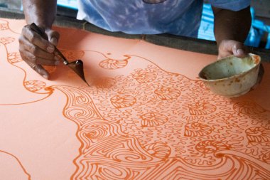 Craftsmanship of thai professional artist working use Tjanting tool or canting equipment and beeswax drawing batik ikat in handmade studio handicrafts workshop at Pak Bara of La ngu in Satun, Thailand clipart