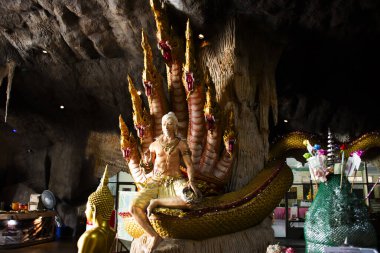 Antique tunnel cave for thai people travel visit respect praying blessing buddha and naga guardian holy deity angel myth worship at Wat BuaKhwan ancient temple on July 29, 2024 in Nonthaburi, Thailand clipart