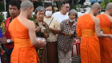 Yerli thai halkı ayine katılıyor. 18 Ekim 2024 'te Nonthaburi, Tayland' da Wat Prasat tapınağında yapılan törende Budist keşiş veya Budizm rahibine bağış yapıyor.