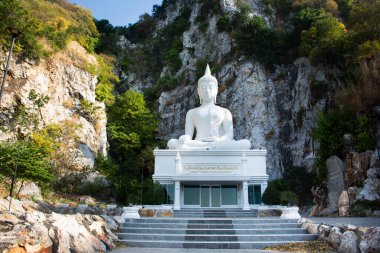 White holy buddha ancient statue on mountain in forest for thai people traveler travel visit respect blessing wish mystery at Wat Khao Wong Narai Cave Temple on November 12, 2024 in Saraburi, Thailand clipart