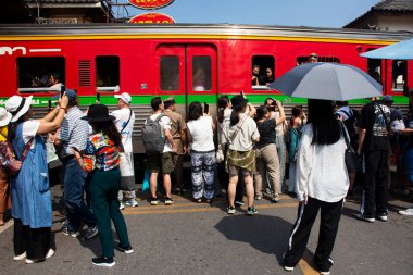 Maeklong Railway Market for thai people foreign traveler travel visit train running in Talad Rom Hub or umbrella pulldown bazaar and buy gift products on November 17, 2024 in Samut Songkhram, Thailand clipart