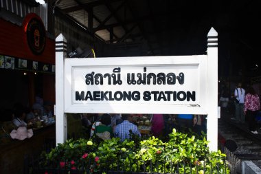 Taylandlı yolcular için Maeklong tren istasyonunun antika mimarisi 17 Kasım 2024 tarihinde Tayland Samut Songkhram 'da Talad Rom Hub pazarında servis tren yolculuğunu kullanıyor.