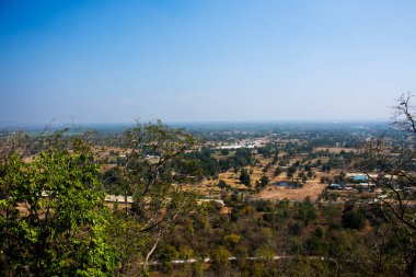 Aerial view landscape of rice field or paddy land and village countryside from viewpoint of Wat Khao Meng Amornmet Temple for thai people travelers travel visit at Pak Phraek in Kanchanaburi, Thailand clipart