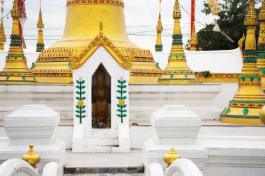 Tayland 'da, Pathum Thani' de Sam Khok 'ta bulunan Wat Chedi Tanga Tapınağı' nda kutsanmış kutsanmış kutsal şeylere saygı duyarak seyahat eden Tayland halkı için antik stupa chedi mon raman tarzı antik Buda heykelleri.