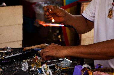 Tayland 'da, Pathum Thani, Tayland' da Sam Khok 'ta el yapımı el yapımı el yapımı el yapımı pazarda cam üretme ve cam üfleme teknikleri yapan usta cam ustası ve sanatçı.